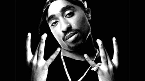 A stunning wallpaper of Tupac Shakur squatting and posing with neon lights behind him on a black background. . Wallpaper tupac